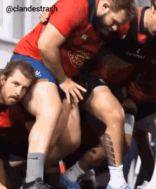 a man in a red shirt with the word catapult on it is being pushed by another man