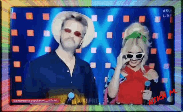 a man and a woman are standing in front of a screen that says " live "