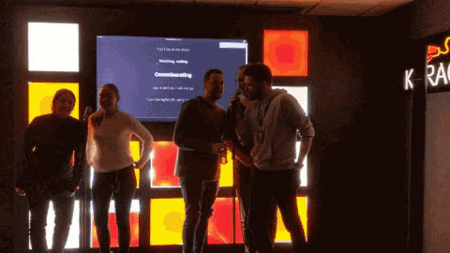 a group of people standing in front of a screen that says ' watching waiting ' on it