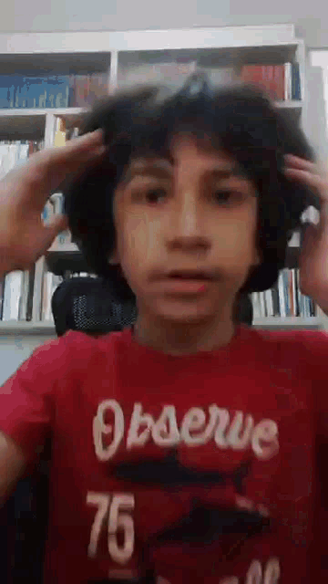 a boy wearing a red shirt that says observe 75 on it