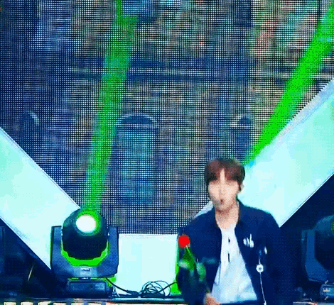 a man is standing in front of a stage with a green light coming out of it .