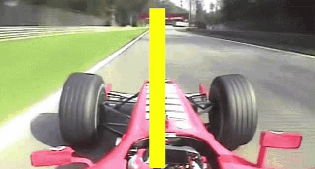 a red race car is driving down a road with a yellow line between the front and back