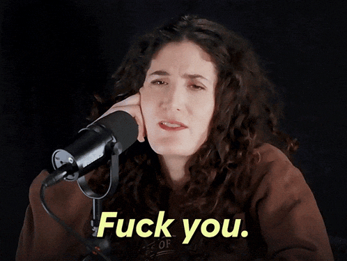 a woman singing into a microphone with the words fuck you on the bottom