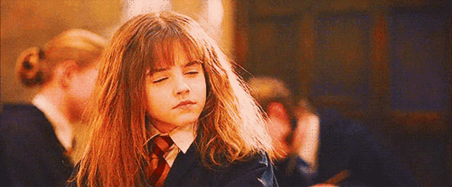 hermione granger from harry potter is wearing a school uniform and a tie .