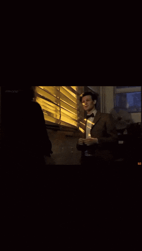 a man in a suit and bow tie is standing in front of a window with the words not a chance on the bottom