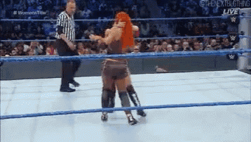 two women are wrestling in a wrestling ring while a referee watches .