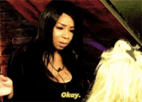 a woman says okay while holding a glass of beer