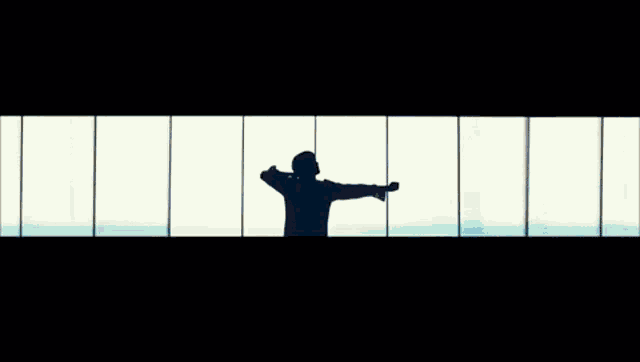 a silhouette of a person standing in front of a wall with a blue and white background