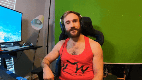 a man is wearing headphones and a red tank top that says wrestling
