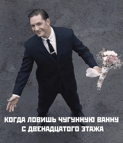 a man in a suit and tie is holding a bouquet of flowers in his hand