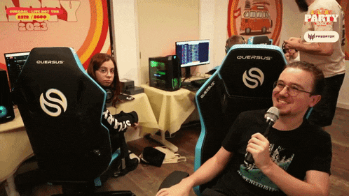 a man is holding a microphone while sitting in a querus chair