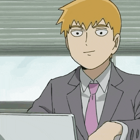 a man in a suit and pink tie is sitting in front of a laptop