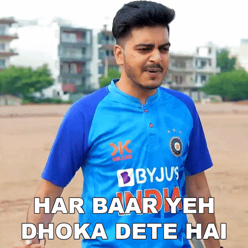 a man wearing a blue byju 's jersey stands on a field