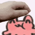 a close up of a person 's hand holding a pink cat .