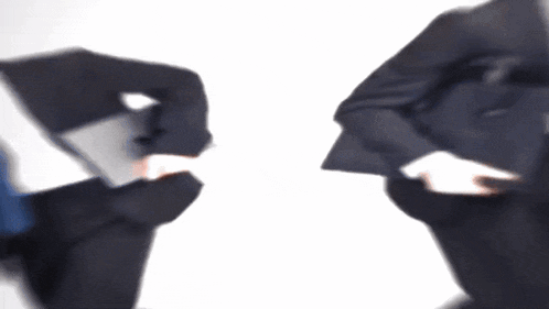 a blurry picture of two men in suits holding laptops