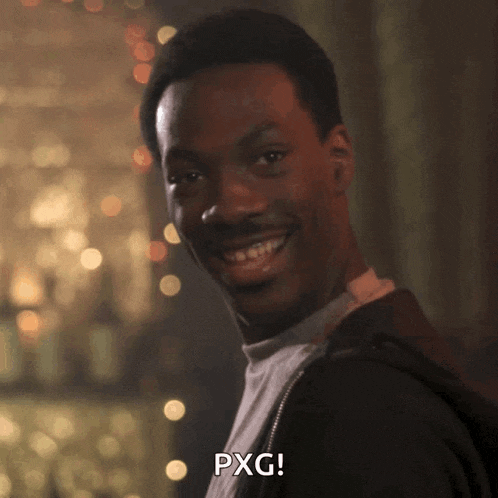 a man is smiling and says pxg in a dark room