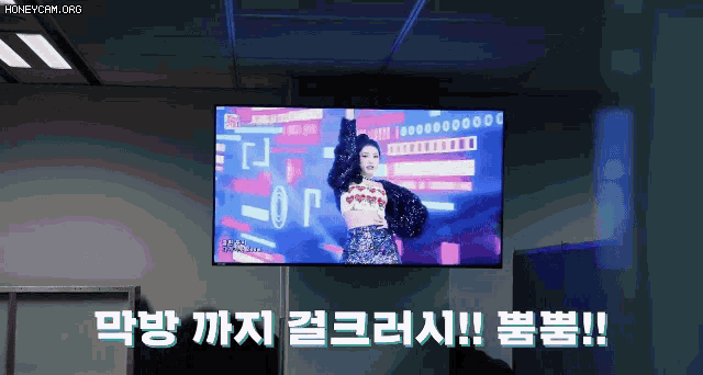a woman is dancing on a tv screen with chinese writing on it