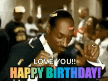 a man in a suit and tie is holding a microphone and singing happy birthday .