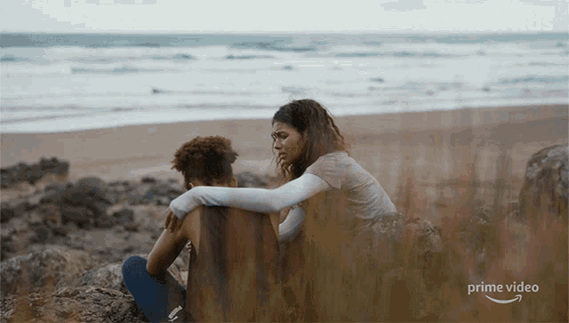 a poster for the wilds shows two women sitting on a beach