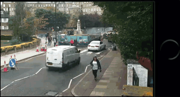 a woman walking down a street with a van that says ' ford ' on the side