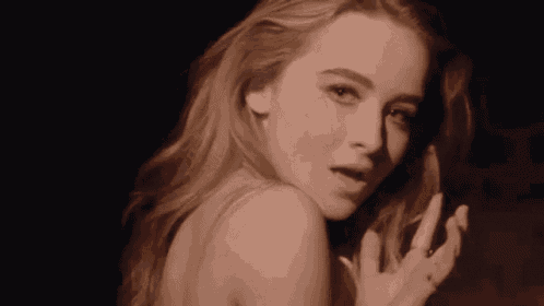 a close up of a woman 's face in a dark room .