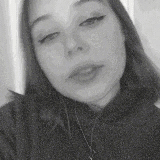 a black and white photo of a woman 's face with her eyes closed
