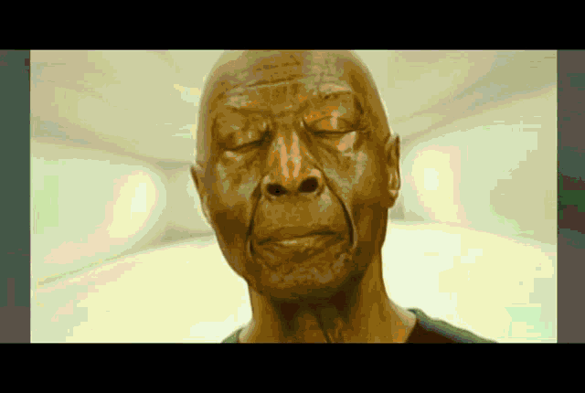 a close up of a man 's face with his eyes closed in a room