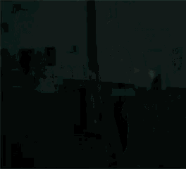a young man in a black shirt is standing in a dark room