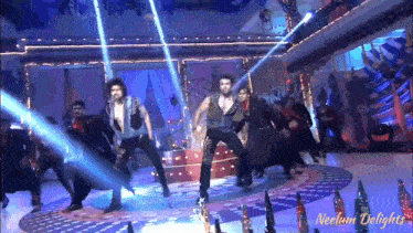a group of people are dancing on a stage and the words neelam delights are on the bottom