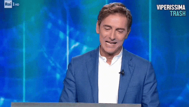 a man in a blue suit says scandalo on a tv show