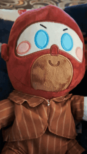 a stuffed monkey wearing a striped jacket and pants