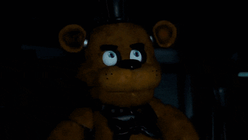 a teddy bear is standing in front of a green exit sign in a dark room .