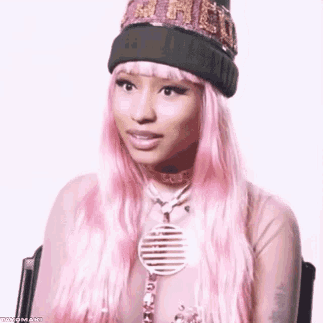 a woman with pink hair is wearing a beanie and a choker .
