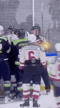 a group of hockey players are standing on the ice and talking to each other .