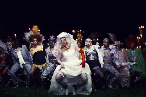 a woman in a bride 's dress is surrounded by other people
