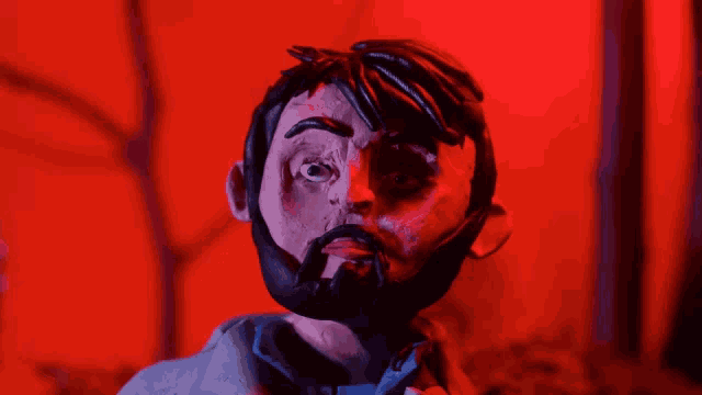a clay figure of a man with a beard looks at the camera