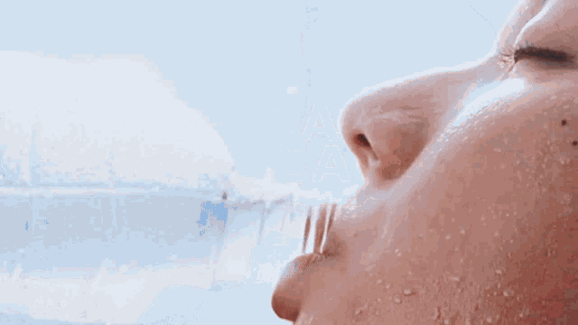 a close up of a woman 's face with water coming out of her mouth