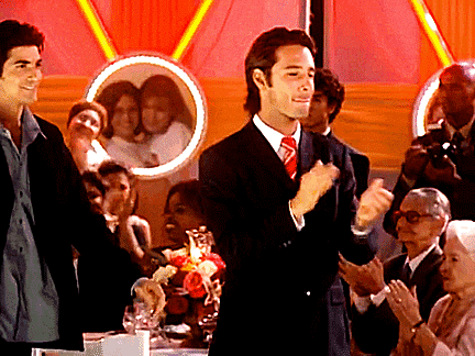 a man in a suit and tie stands in front of a group of people