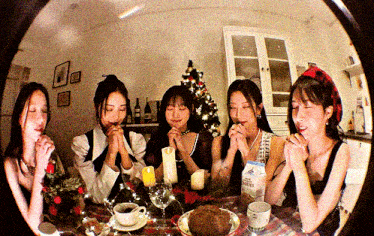 a group of women praying at a table with a box of milk