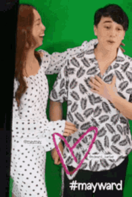 a man and a woman standing next to each other with a heart drawn on their chest