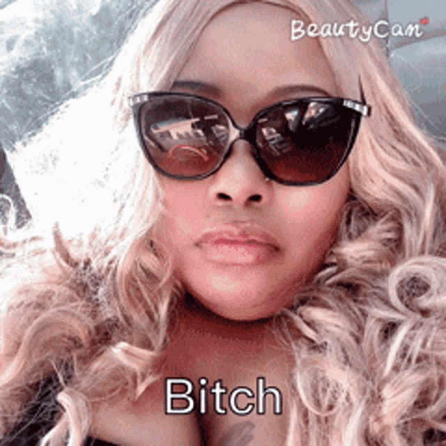 a woman wearing sunglasses has the word bitch on her chest