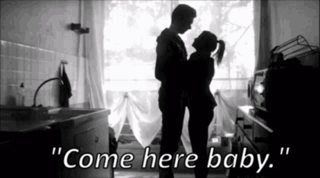 a black and white photo of a man and woman standing next to each other with the words " come here baby " below them