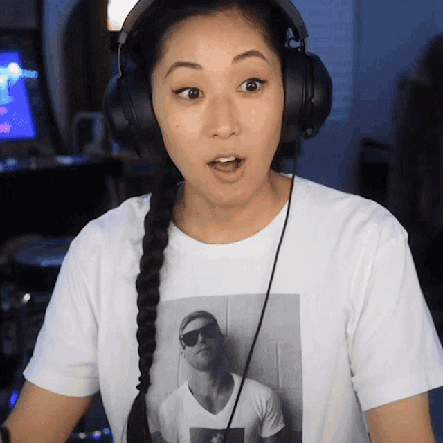 a woman wearing headphones and a white shirt with a picture of a man