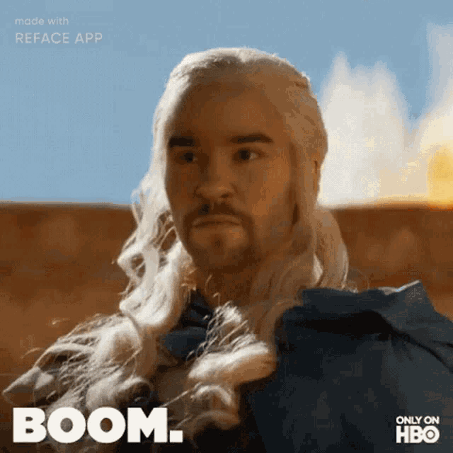 a man with long blonde hair and a beard says boom on a screen