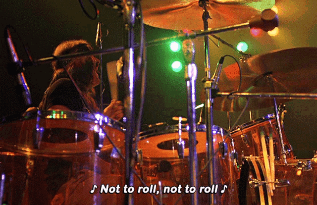 a man playing drums with the words " not to roll " above him