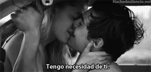 a black and white photo of a man and woman kissing with the words tengo necesidad de ti written below them .
