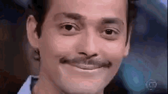 a man with a mustache is making a funny face and smiling .