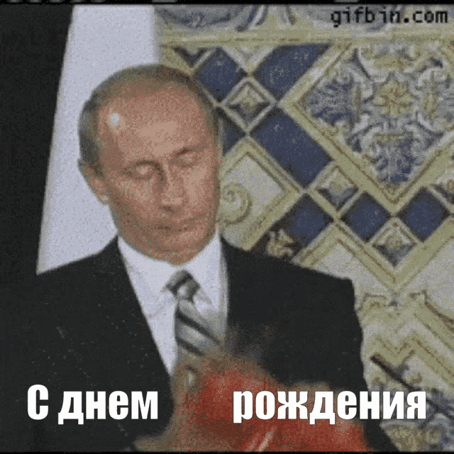 a man in a suit and tie is holding a red boxing glove and says " с днем рождения " in russian