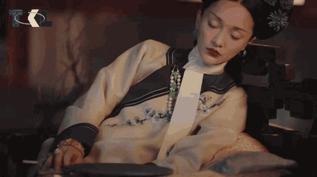 a woman in a traditional chinese dress is laying down