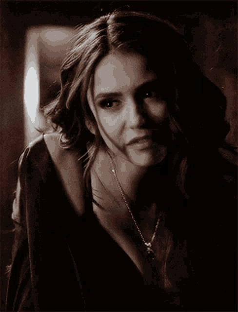 a close up of a woman wearing a black bra and necklace